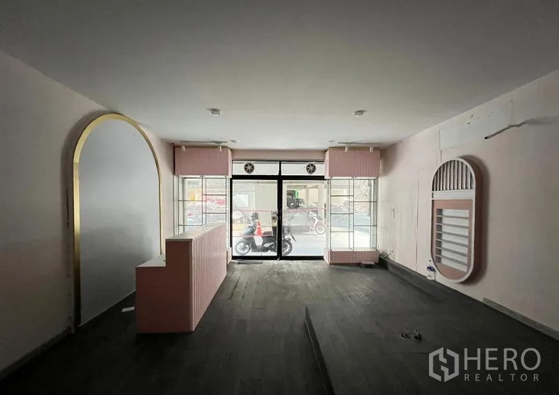 Shophouse for rent in Watthana, Bangkok - Interior view toward the entrance showing twin display windows and central raised flooring.