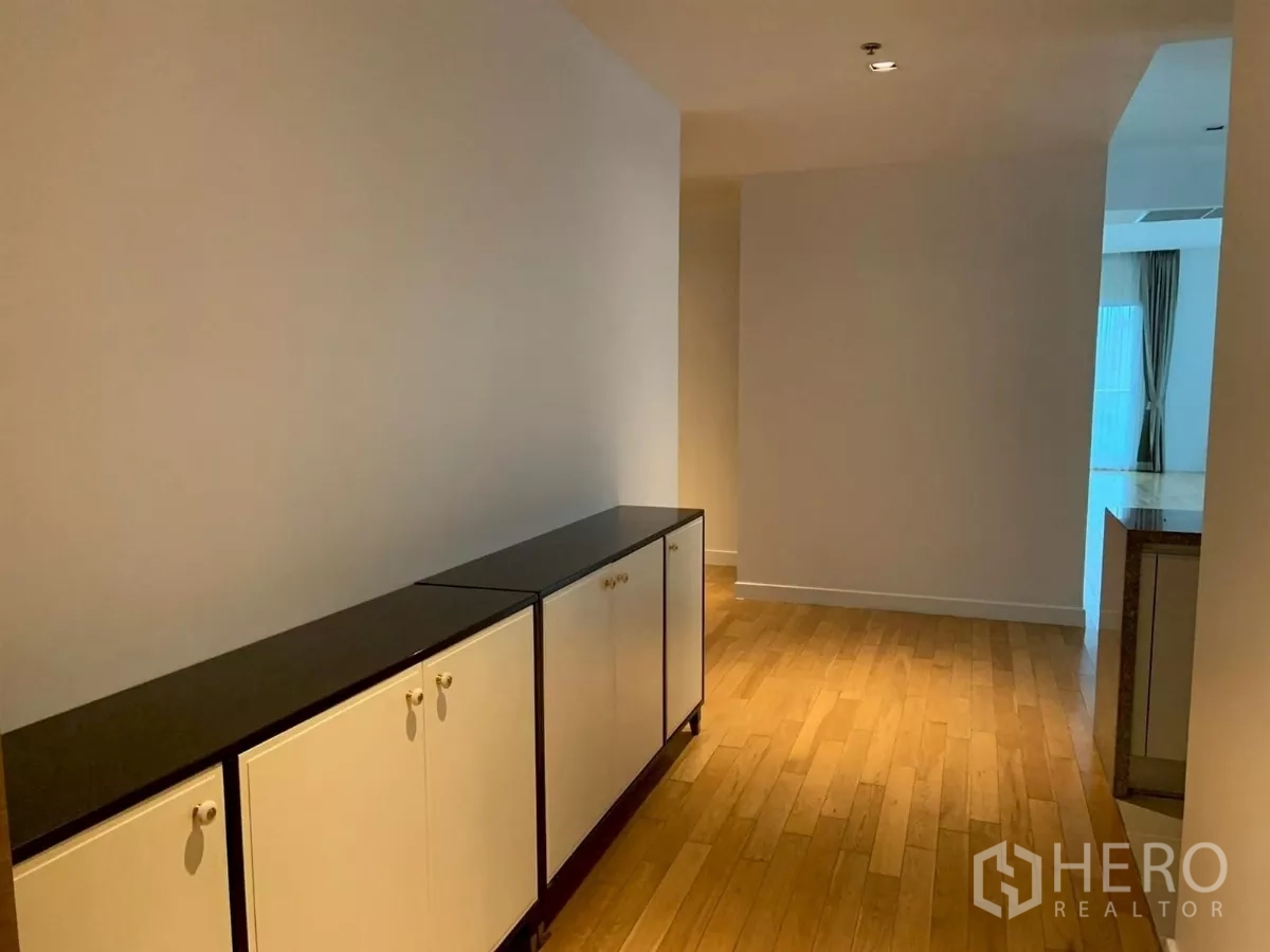 Condominium for rent in Khlong Toei, Bangkok - Entrance corridor with low storage cabinets and wood flooring.