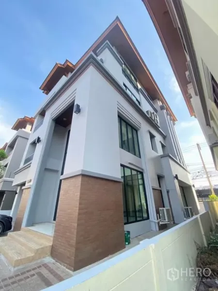 带办公室的家 出租在Wang Thonglang, Bangkok - 建筑侧立面视角，转角位置，配大窗与砖纹立面。