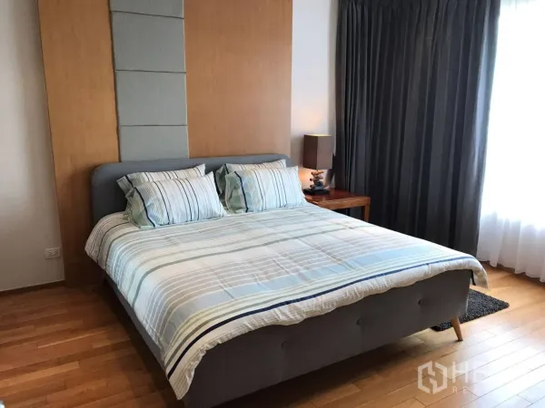 公寓 出租或出售在Khlong Toei, Bangkok - 明亮卧室：条纹床品的双人床、软包床头、木地板与遮光窗帘。