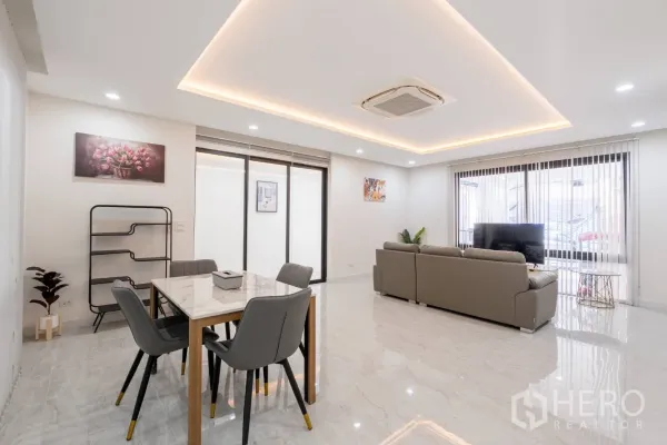 Home Office for rent in Khlong Toei, Bangkok - Bright open-plan living and dining area with recessed lighting and glossy marble-look floors.