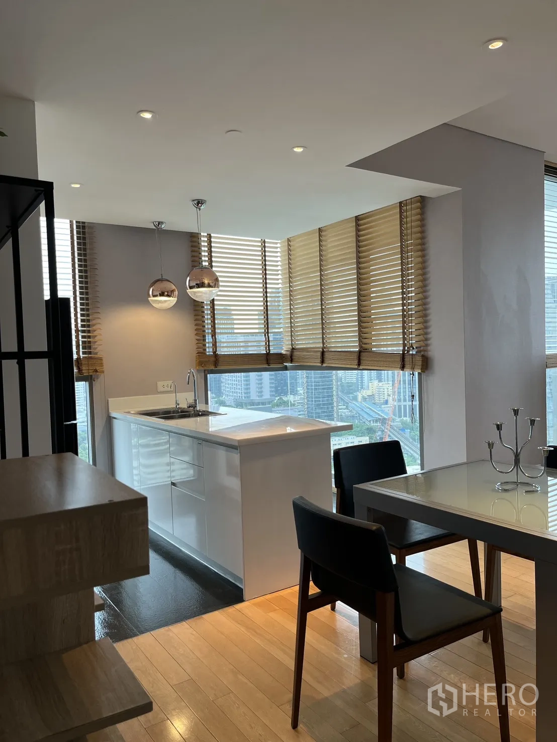 Condominium for rent in Watthana, Bangkok - Bright open kitchen with white island, pendant lights, and skyline outlook.
