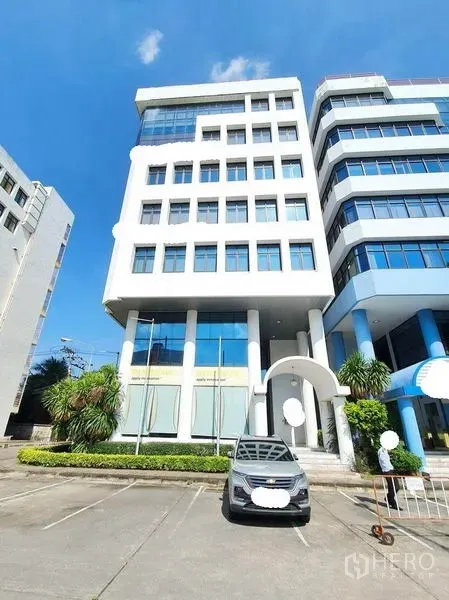 Office Space for rent in Bang Na, Bangkok - Expansive office floor with angled windows, ceiling lights and AC vents.