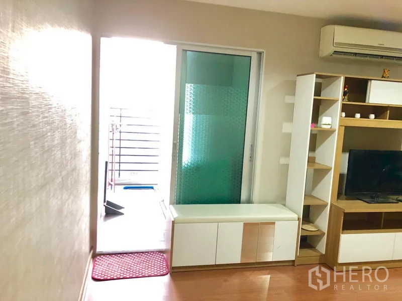 คอนโด ให้เช่าในHuai Khwang, Bangkok - พื้นที่นั่งเล่นพร้อมชั้นวางทีวี ชั้นเก็บของ แอร์ และประตูกระจกบานเลื่อนไปยังระเบียง