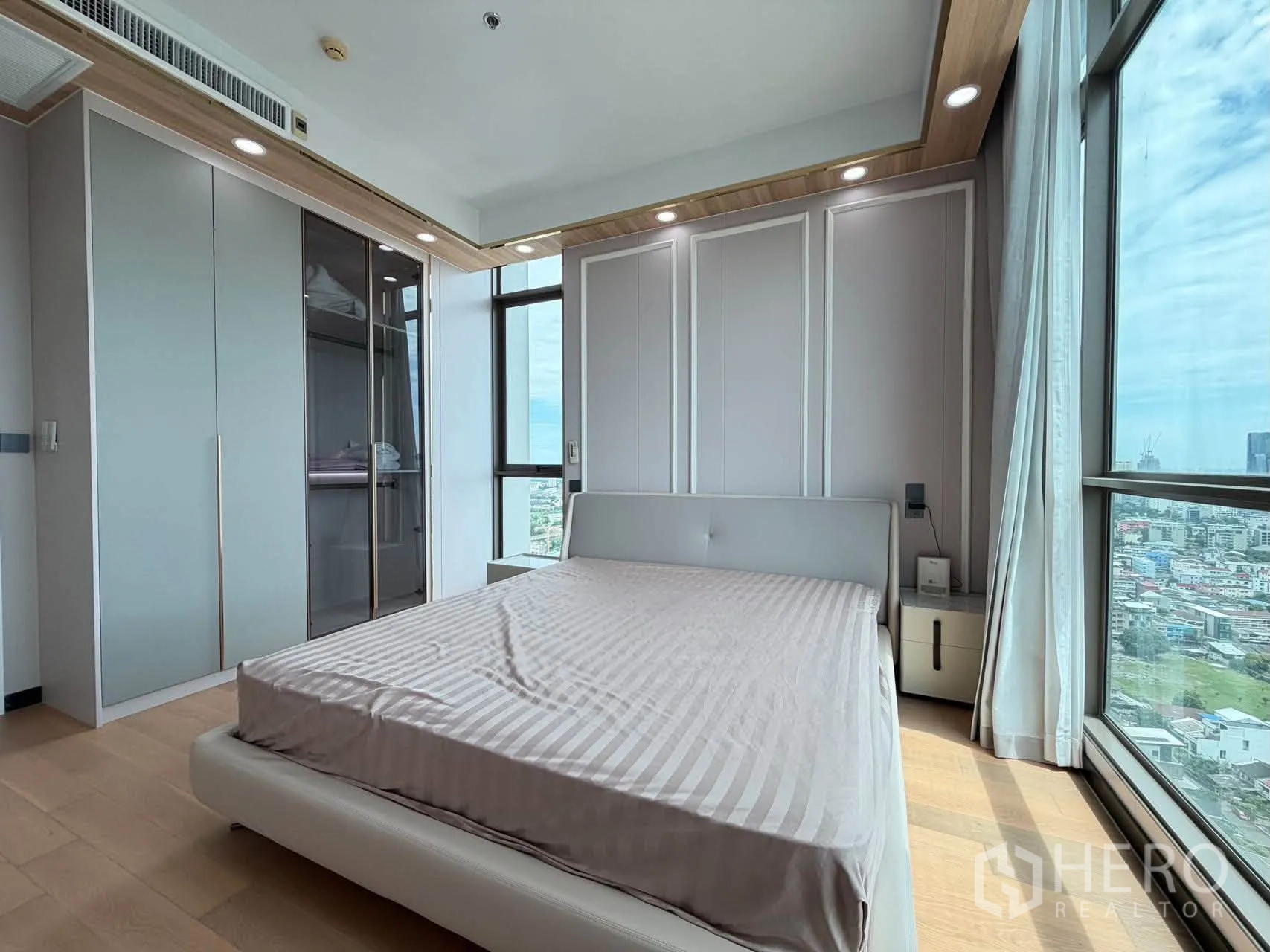 Condominium for sale in Watthana, Bangkok - Bright bedroom with bed, built-in wardrobe, and floor-to-ceiling city view windows.
