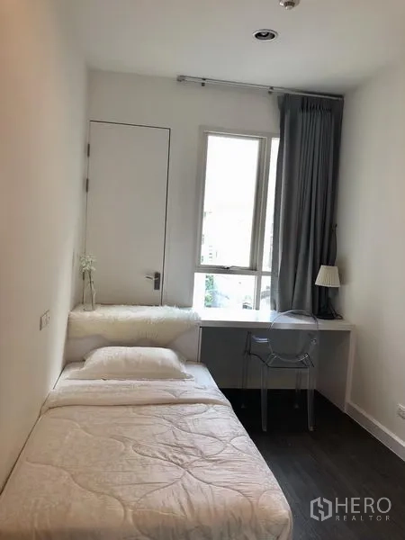 公寓 出租在Pathum Wan, Bangkok - 温馨单人卧室，窗边书桌与灰色窗帘。