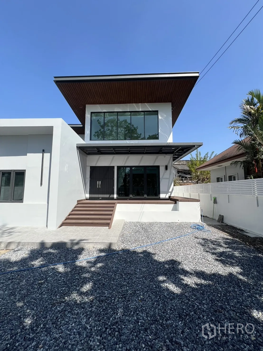 Detached House for rent in Saphan Sung, Bangkok - Front facade showing wide steps, large windows and a striking slanted roofline.