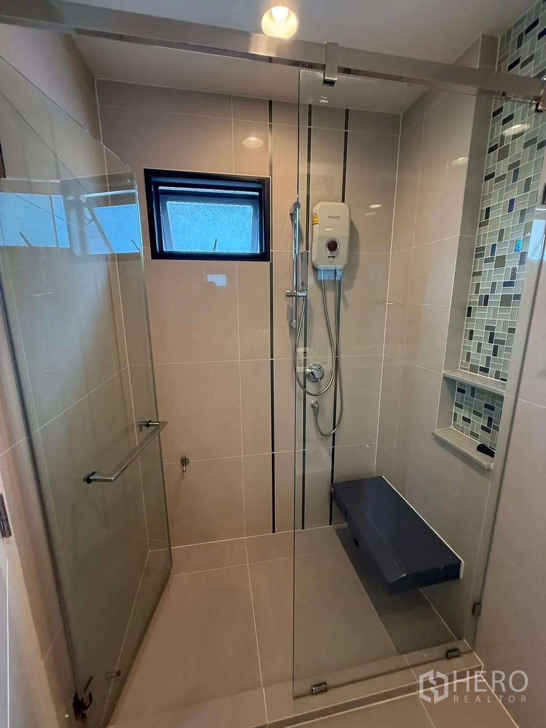 Detached House for rent in Prawet, Bangkok - Glass-enclosed shower with handheld shower, water heater, mosaic niche and built-in bench.
