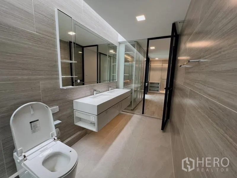 Detached House for rent or sale in Saphan Sung, Bangkok - View of the ensuite bathroom looking back toward the dressing room with glass partitions.