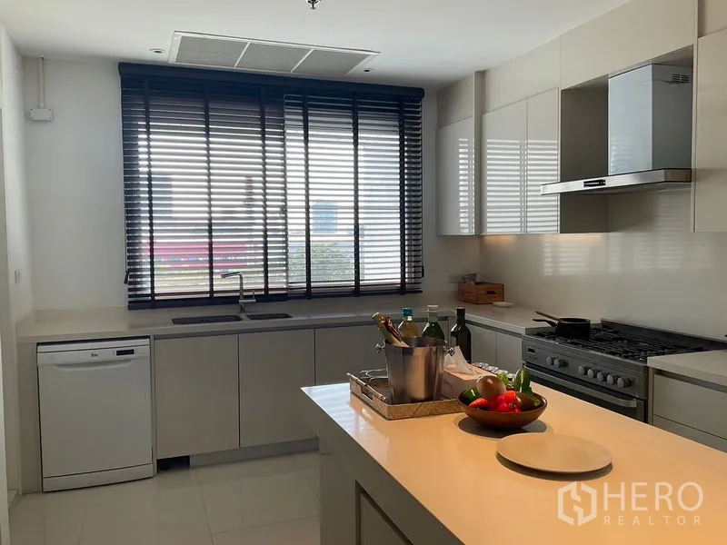 Apartment for rent in Sathon, Bangkok - Secondary kitchen with large window, gas stove, hood and central island.