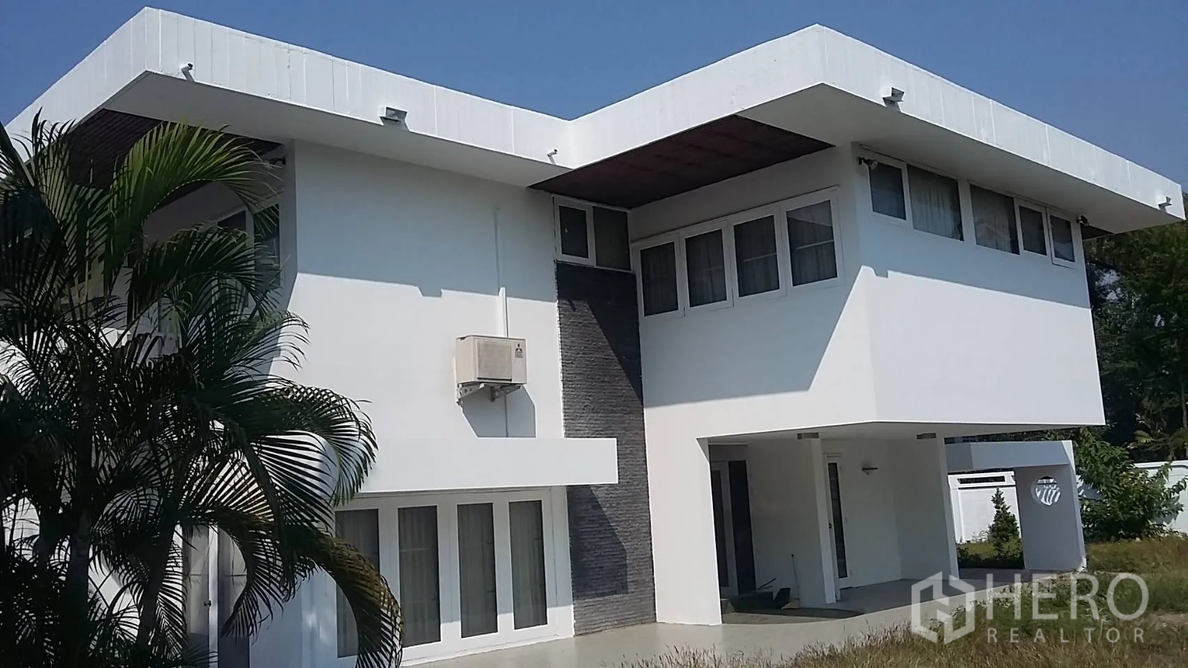 独立式住宅 出租在Khlong Toei, Bangkok - 当代独栋住宅正立面，平屋顶与有顶车位。