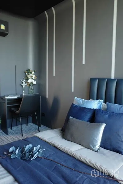 Condominium for sale - Cozy bedroom with study desk, grey walls and vertical light strips.