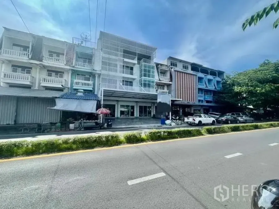 Home Office for rent or sale in Bang Kapi, Bangkok - Row of renovated shophouses on a four‑lane road showing the home office building with wide frontage and roadside parking in Bang Kapi.