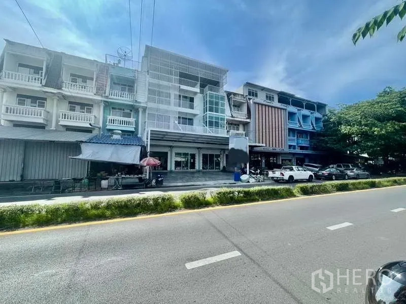 Home Office for rent or sale in Bang Kapi, Bangkok - Row of renovated shophouses on a four‑lane road showing the home office building with wide frontage and roadside parking in Bang Kapi.
