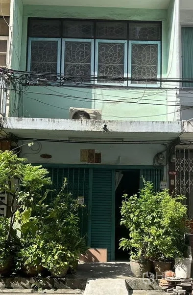 店屋 出租或出售在Watthana, Bangkok - 两层浅绿色店屋立面，金属卷闸门与盆栽绿植。