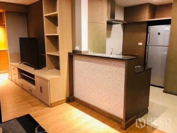 Condominium for rent in Watthana, Bangkok - Compact kitchen with breakfast bar, mosaic front, stainless refrigerator and built‑in TV cabinet.