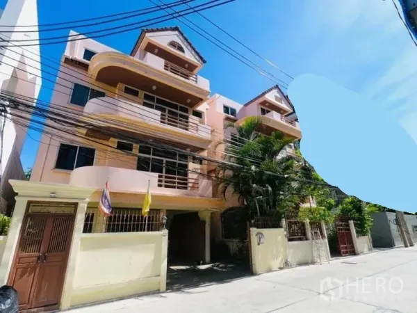 Detached House for rent in Watthana, Bangkok - Facade of the house with balconies, gated entrance and tropical trees in Watthana.