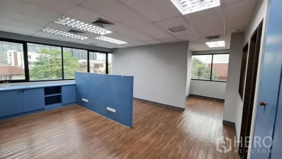办公空间 出租在Watthana, Bangkok - 明亮开放式办公室，木地板、蓝色柜体与大面积窗户。