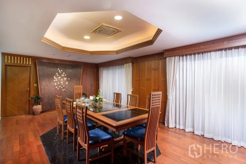 Condominium for rent or sale in Ratchathewi, Bangkok - Another angle of the dining area with floor-to-ceiling curtains and built-in wood details.