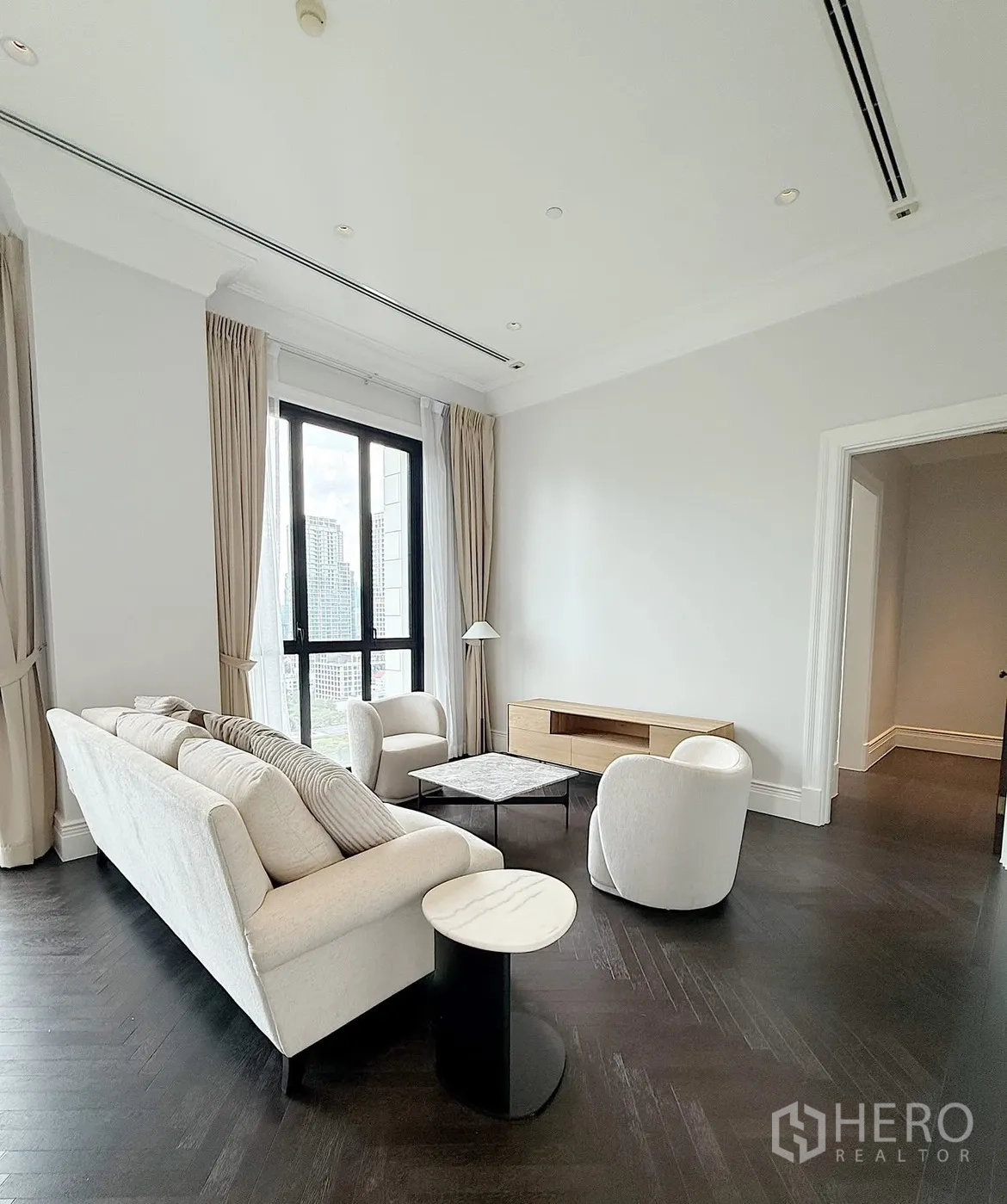 คอนโด for rent or sale in Pathum Wan, Bangkok - ห้องนั่งเล่นมินิมอลพร้อมโซฟา เก้าอี้นวม โต๊ะกลางหินอ่อน และชั้นวางทีวี
