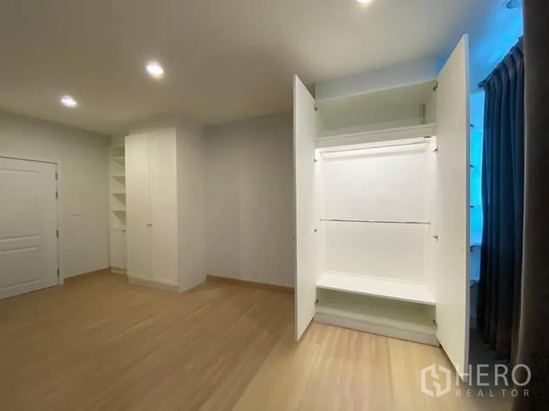 Townhouse for rent in Bang Na, Bangkok - Open built‑in wardrobe displaying storage space in a bright bedroom.