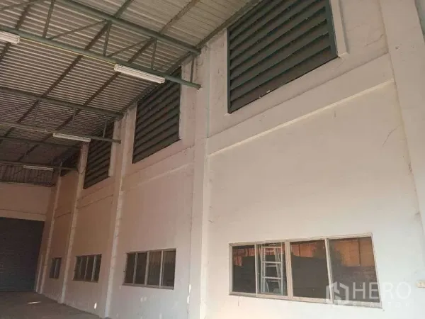 Factory for rent in Mueang Samut Prakan, Samut Prakan - High-clear factory interior with louvered ventilation panels, windows, and a steel roof structure.