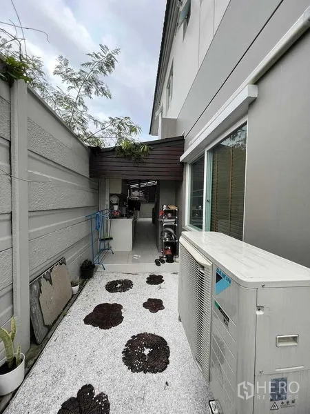 独立式住宅 出租或出售在Lat Krabang, Bangkok - 后方服务庭院，白色碎石地与空调室外机、雨棚。