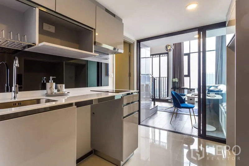 Condominium for rent - Sleek galley kitchen opening to a glass-partitioned living area.