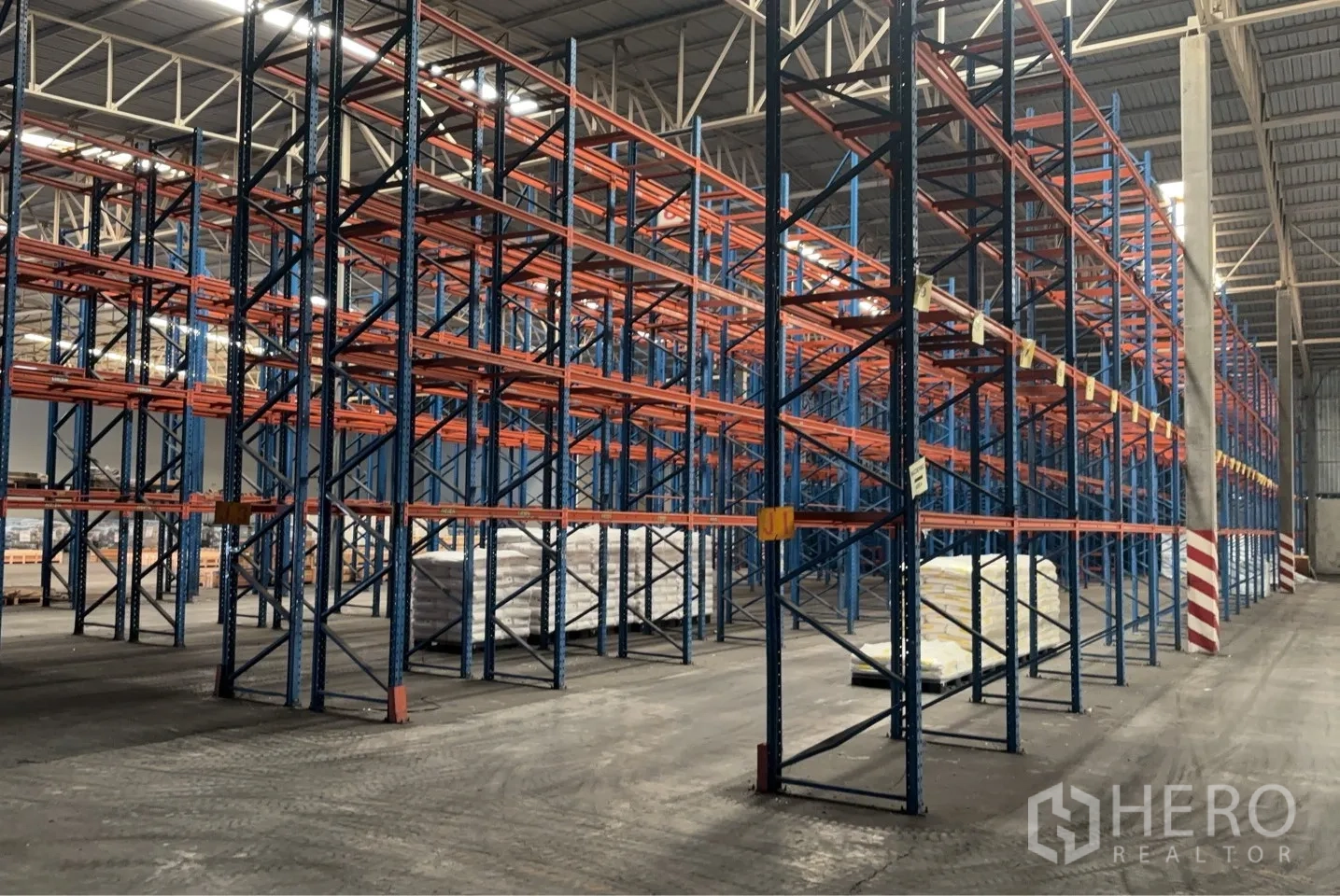 Warehouse for rent in Bang Pa-in, Phra Nakhon Si Ayutthaya - Angle view of extensive steel pallet racks inside a bright warehouse with concrete flooring and spacious aisles.