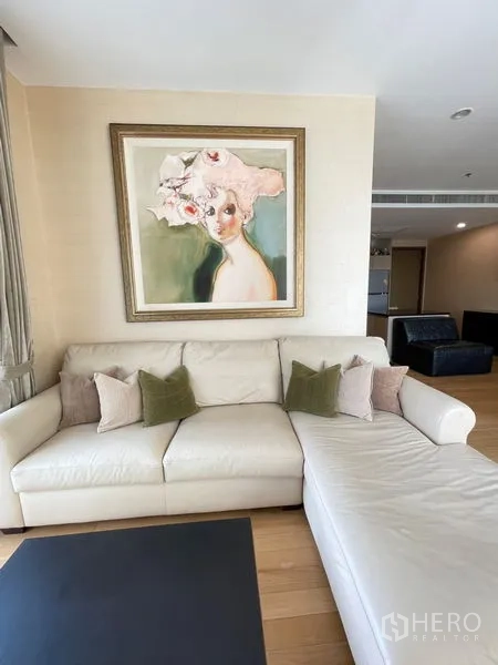 Condominium for rent in Watthana, Bangkok - Cozy living corner with cream L-shaped sofa and framed artwork.