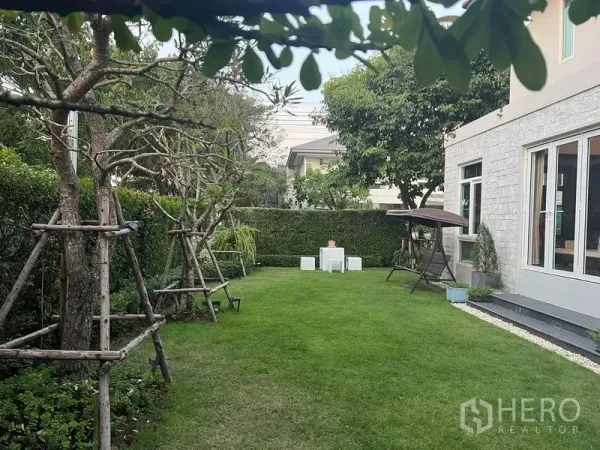 บ้าน ขายในPrawet, Bangkok - สวนหลังบ้านกว้าง พร้อมแนวรั้วต้นไม้และมุมที่นั่งพักผ่อน