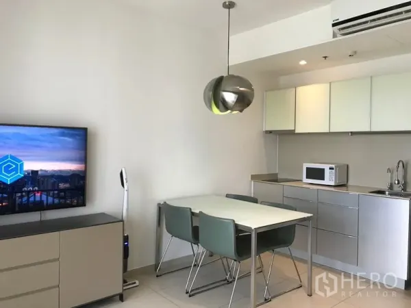 公寓 出租在Watthana, Bangkok - 艾卡迈公寓的用餐区与紧凑厨房，吊灯与微波炉