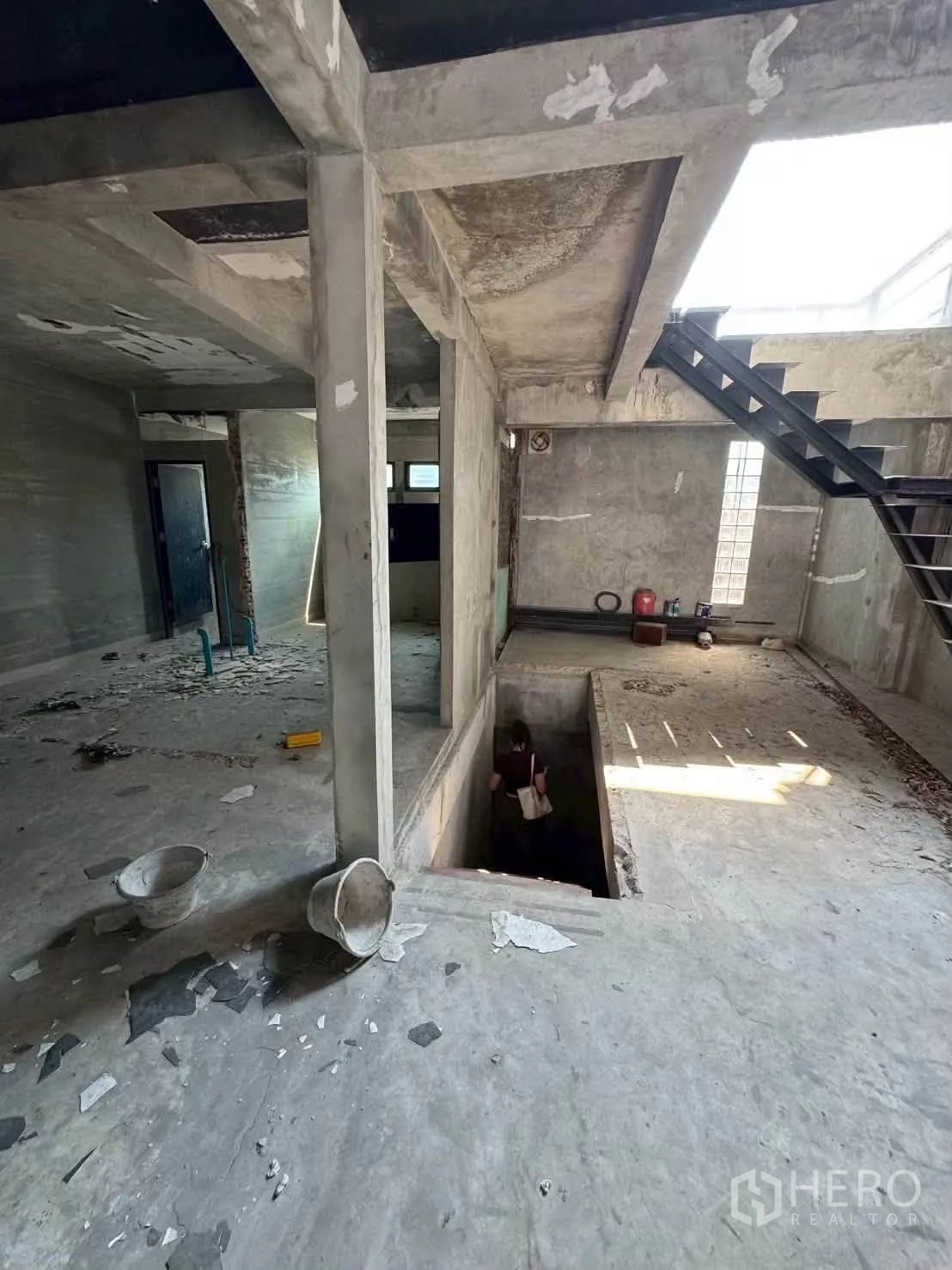 Shophouse for rent in Khlong Toei, Bangkok - Open-plan floor with concrete columns, staircase opening, and natural light.