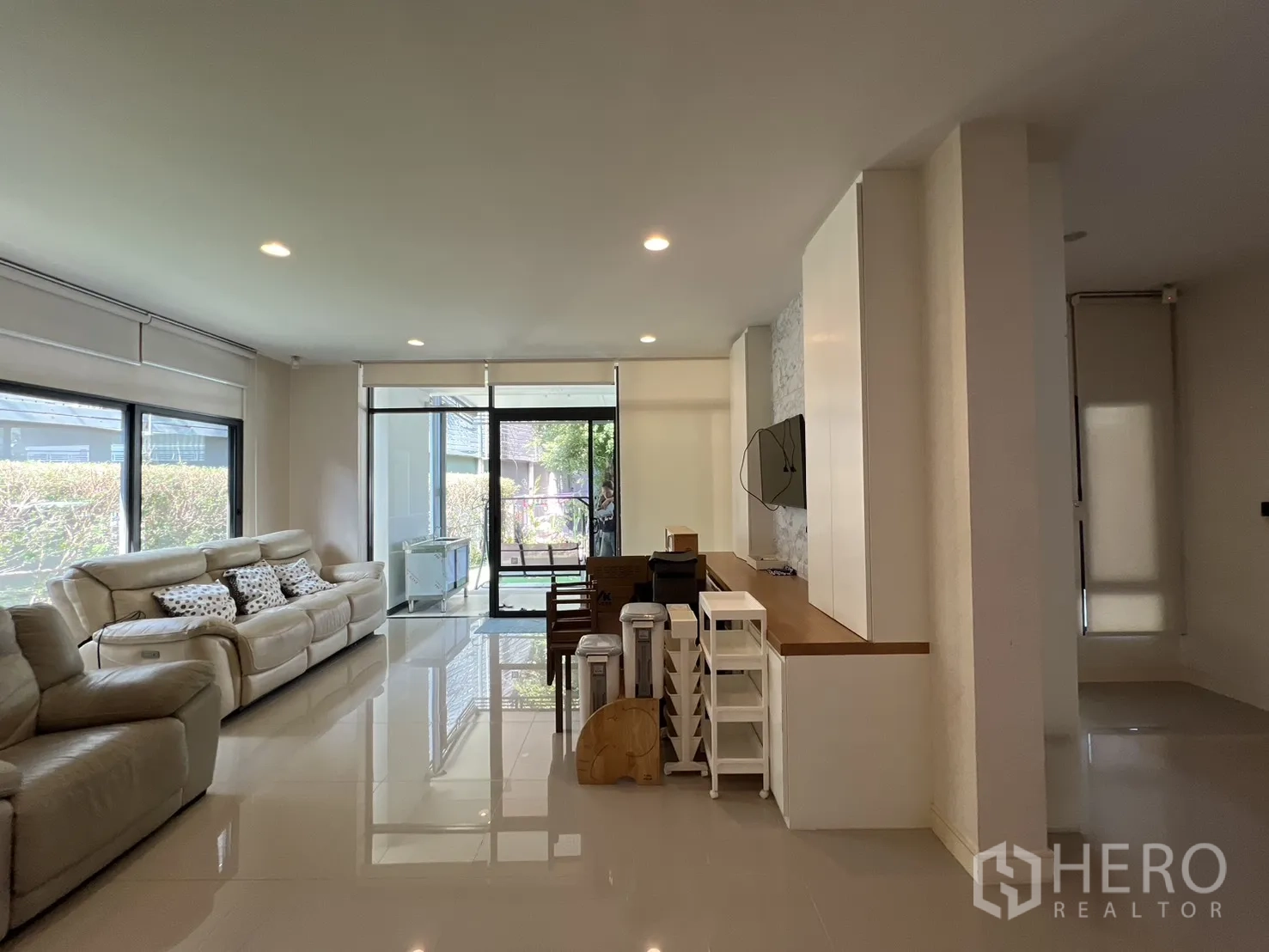 Detached House for sale in Bang Kapi, Bangkok - Bright open-plan living area with large windows and cream sofas.