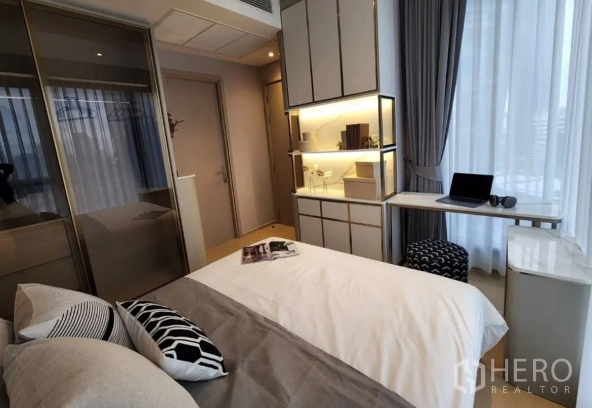 Condominium for rent in Din Daeng, Bangkok - Bedroom with large windows, study desk, and illuminated built-in storage.
