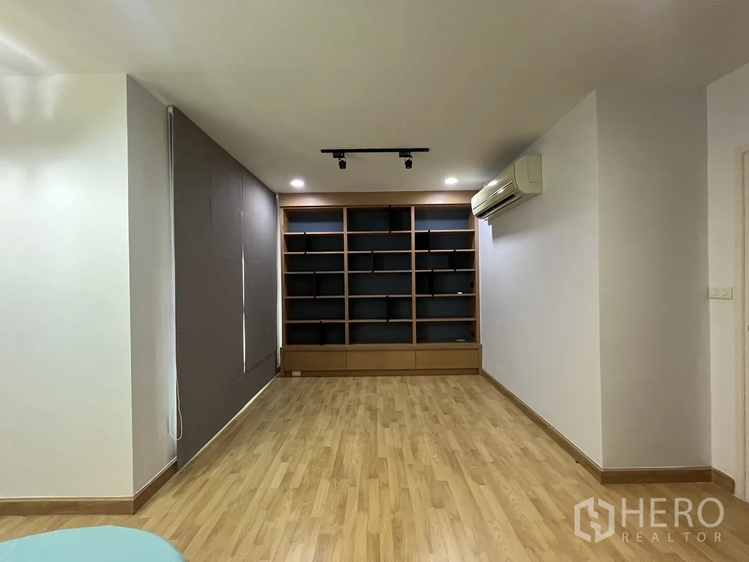 联排别墅 出租在Wang Thonglang, Bangkok - 宽阔多功能室，整面墙书柜与轨道灯。