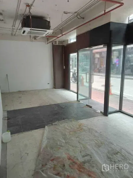 Retail Space for rent in Watthana, Bangkok - Ground-floor retail interior with floor-to-ceiling glass frontage, tiled flooring and exposed ceiling with air-conditioning.
