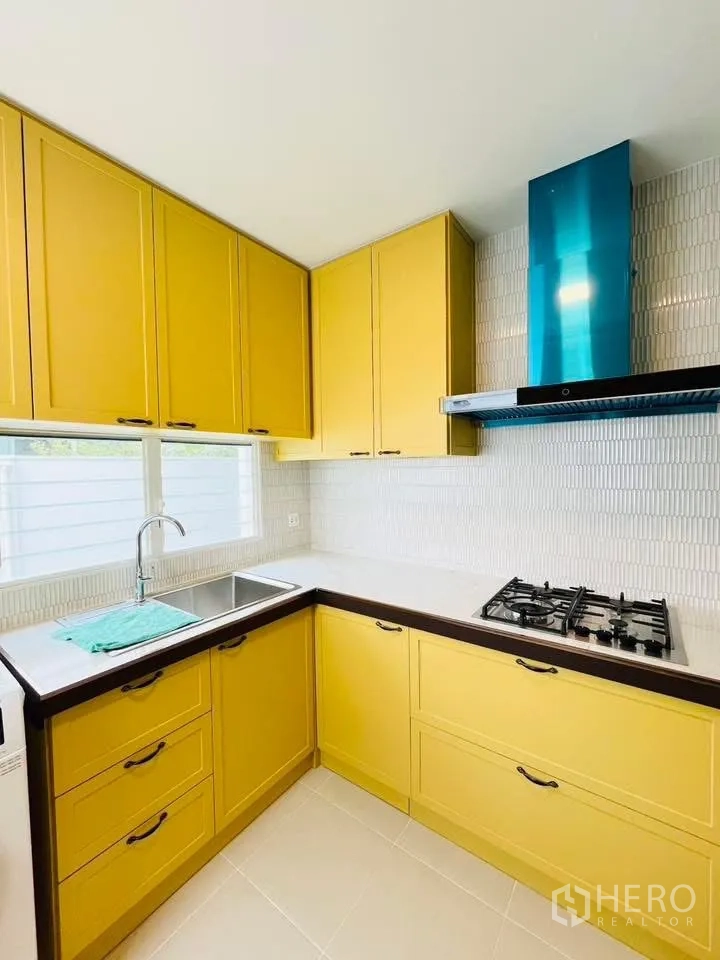 บ้านเดี่ยว for rent in Bang Phli, Samut Prakan - มุมครัวสว่างตู้สีเหลือง เตาแก๊ส และฮูดดูดควัน.