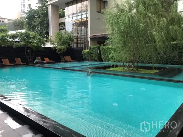 คอนโด ให้เช่าหรือขายในKhlong Toei, Bangkok - สระว่ายน้ำกลางแจ้งสไตล์รีสอร์ต พร้อมเก้าอี้อาบแดดและสวนสวยในคอนโด