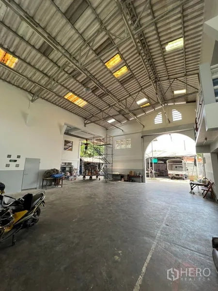 货栈 出租在Thung Khru, Bangkok - 面向大型拱形装卸口的内景，宽阔作业区与夹层平台。