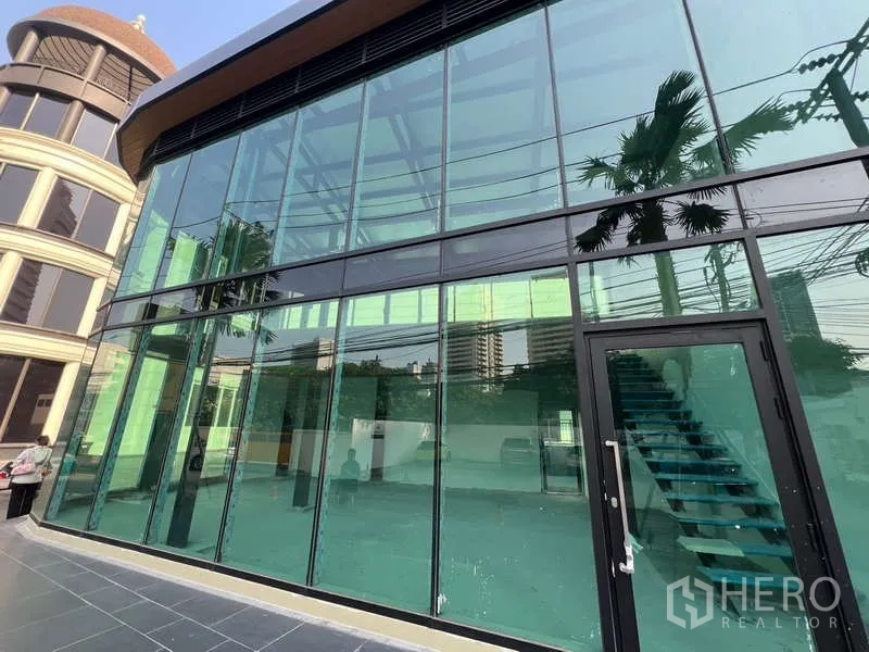 Retail Space for rent in Watthana, Bangkok - Street-facing glass storefront with entrance door and internal stairs visible.