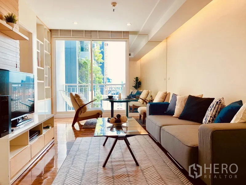 公寓 出租在Watthana, Bangkok - 宽敞客厅连通阳台，设座椅，可欣赏城市景观