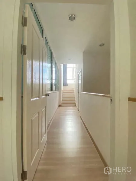 Home Office for rent or sale - Bright upper-floor corridor with wood flooring leading to stairs and bedrooms.