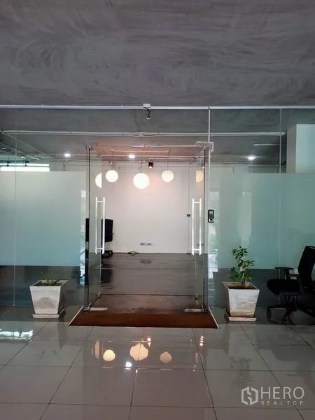 办公空间 出租在Khlong Toei, Bangkok - 办公室玻璃双开入口，吊灯与盆栽点缀。