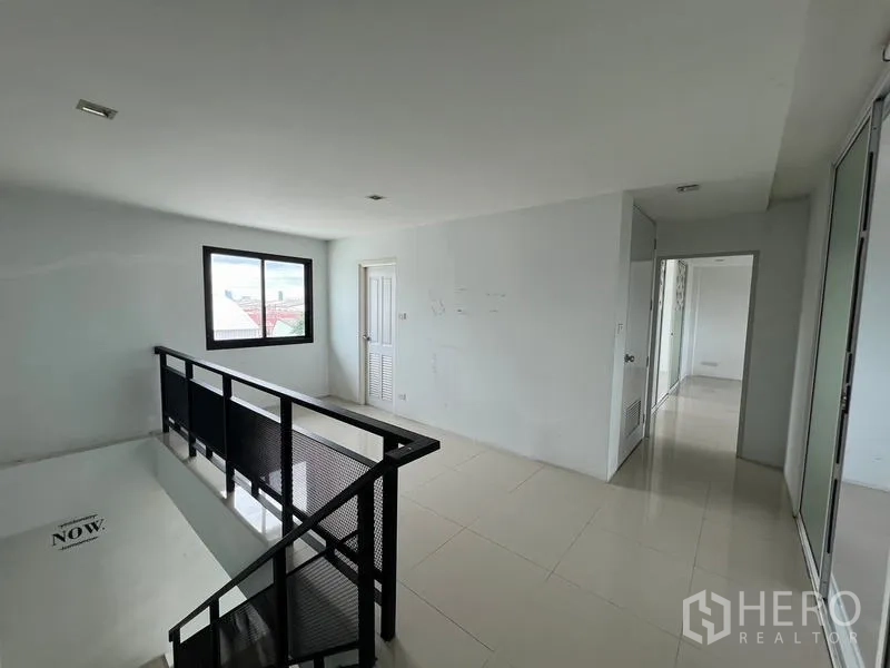 货栈 出租在Bang Phli, Samut Prakan - 楼梯平台，黑色金属栏杆与通往更多办公室的走廊。