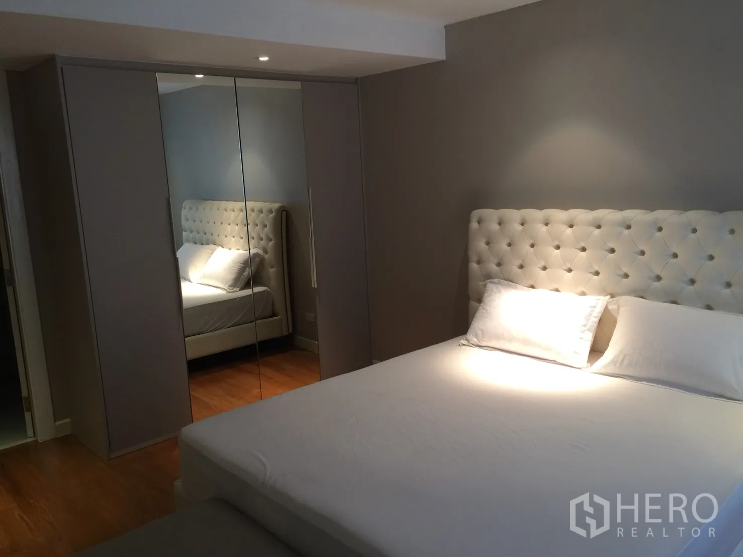 公寓 出租在Watthana, Bangkok - 卧室内设软包床，对面为通顶镜面衣柜。