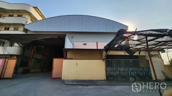 คลังสินค้า ให้เช่าในNonthaburi - มุมมองด้านหน้าโกดังผนังเมทัลชีทพร้อมประตูบานเลื่อนกว้าง ในย่านบางบัวทอง
