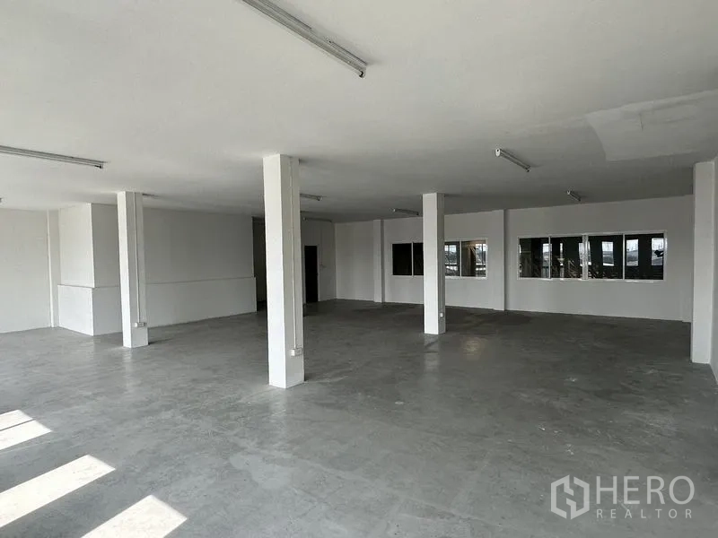 Factory for rent in Bang Sao Thong, Samut Prakan - Large open office level with multiple columns and windows providing natural light.