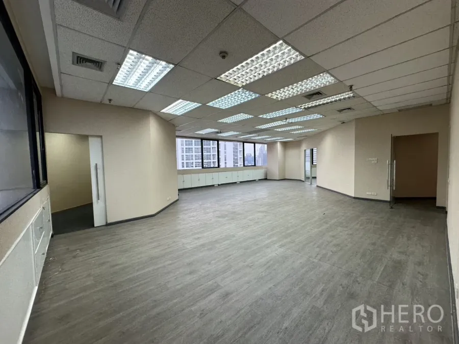 Office Space for rent in Bang Rak, Bangkok - Large open-plan office with fluorescent grid lights and city-view windows.