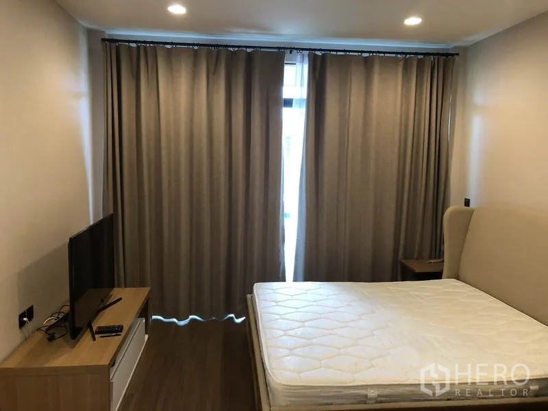 Detached House for rent in Bang Kapi, Bangkok - Master bedroom with bed, TV console and blackout curtains.